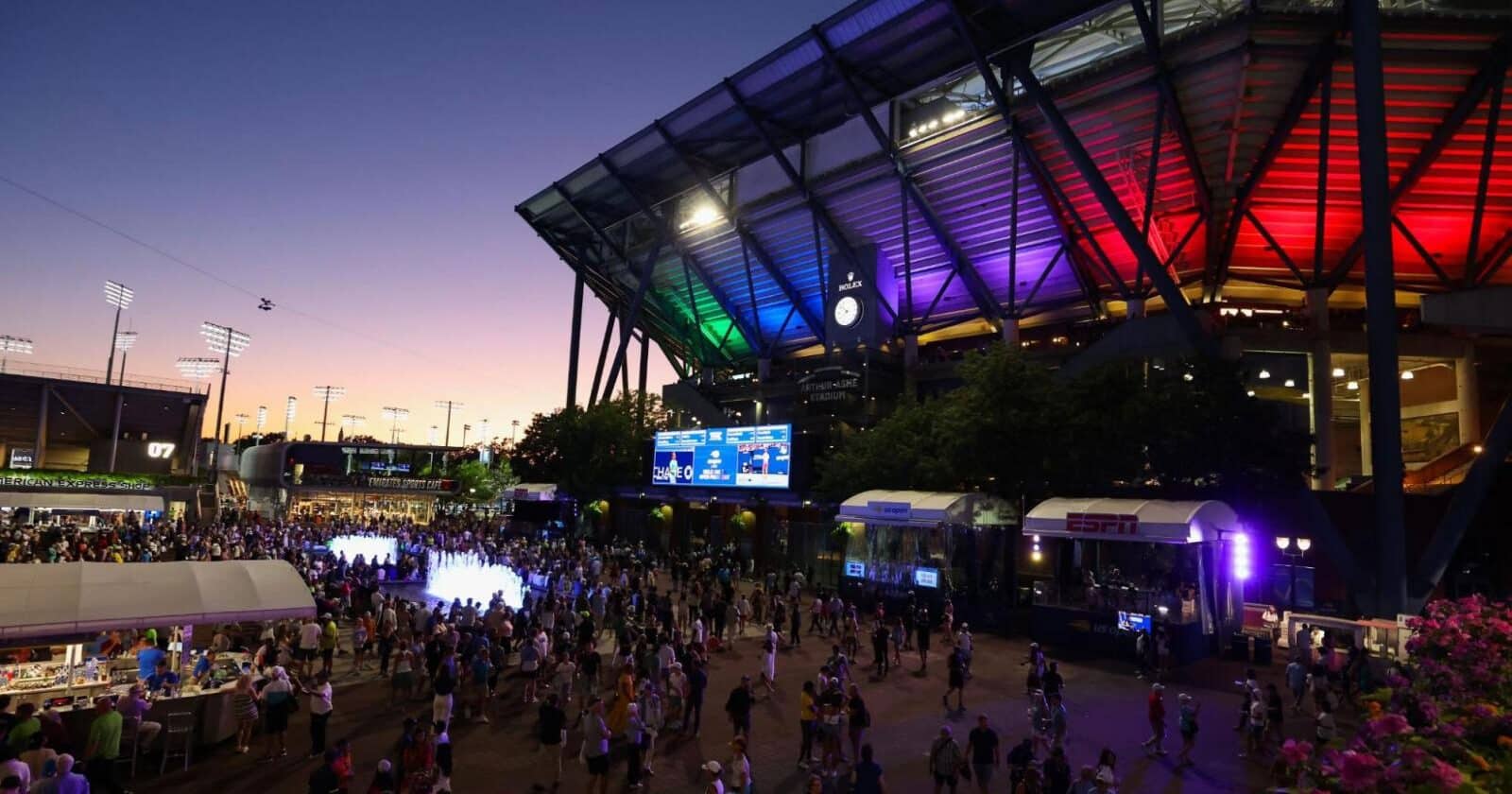 A crowd outside the US Open stadium at night