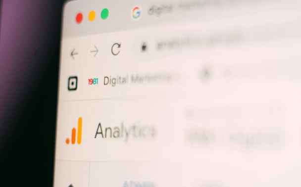 A close-up of a computer screen shows a web browser open to an analytics dashboard, with the Google Analytics logo visible. The page is slightly blurred.