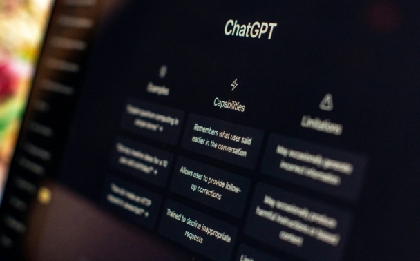 A computer screen displays the ChatGPT interface, highlighting the “Capabilities” section with surrounding text for examples and limitations, all against a dark background.
