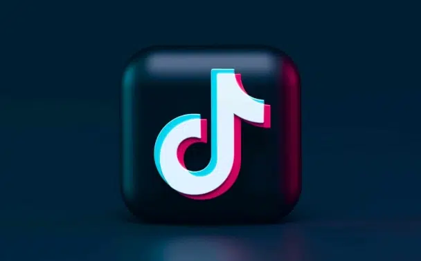 A 3D black square button with the TikTok logo in white, blue, and pink on a dark blue background.